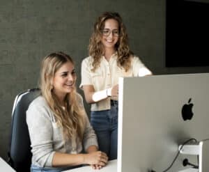 Collega's werken samen en kijken naar computer.