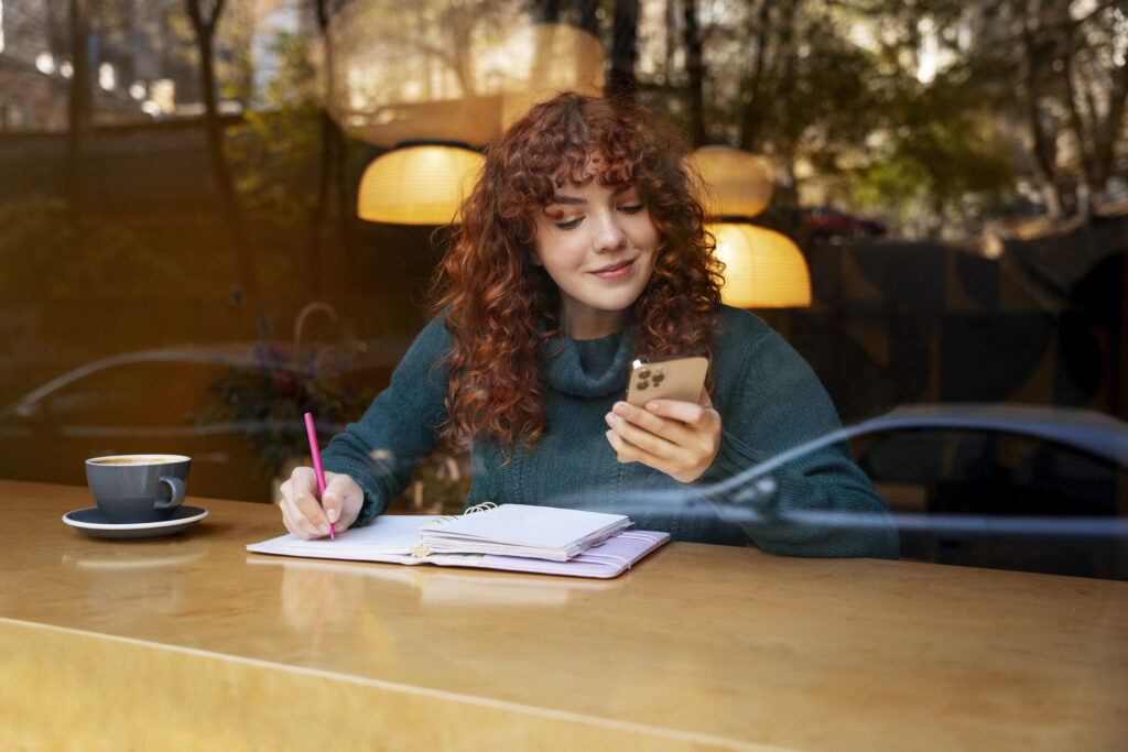 Vrouw aan het werk met notitieboekje en telefoon.