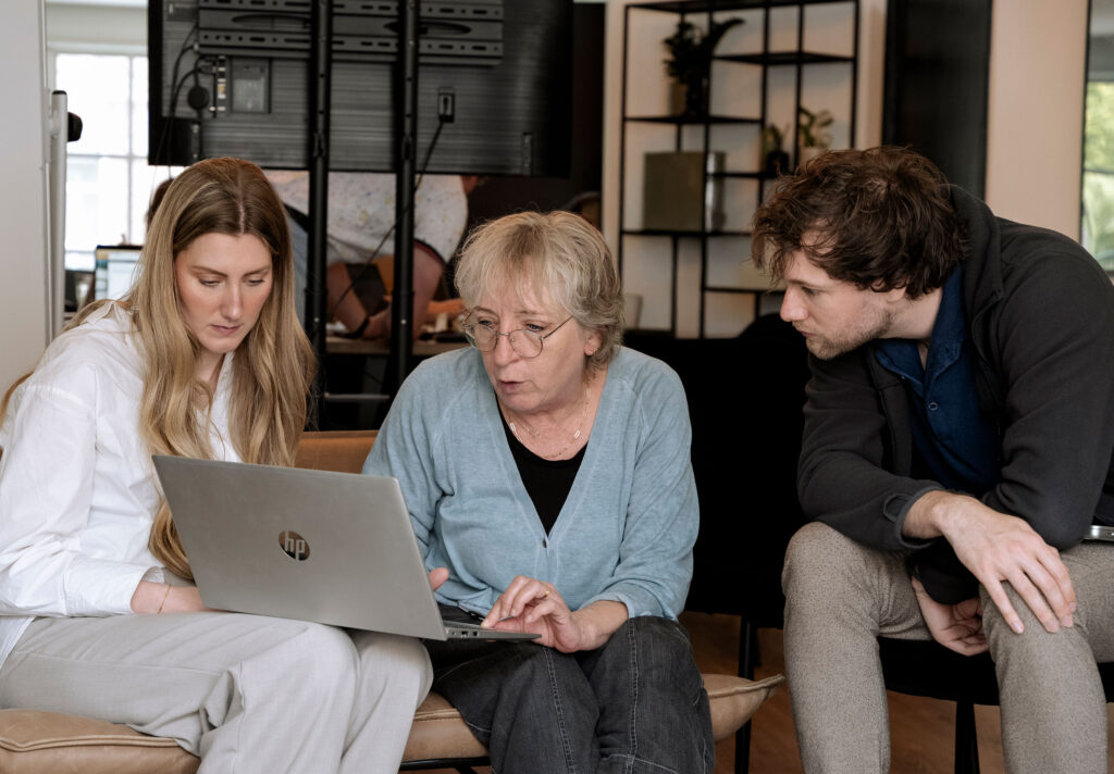Afbeelding van twee vragen en een man die naar een laptop kijken.